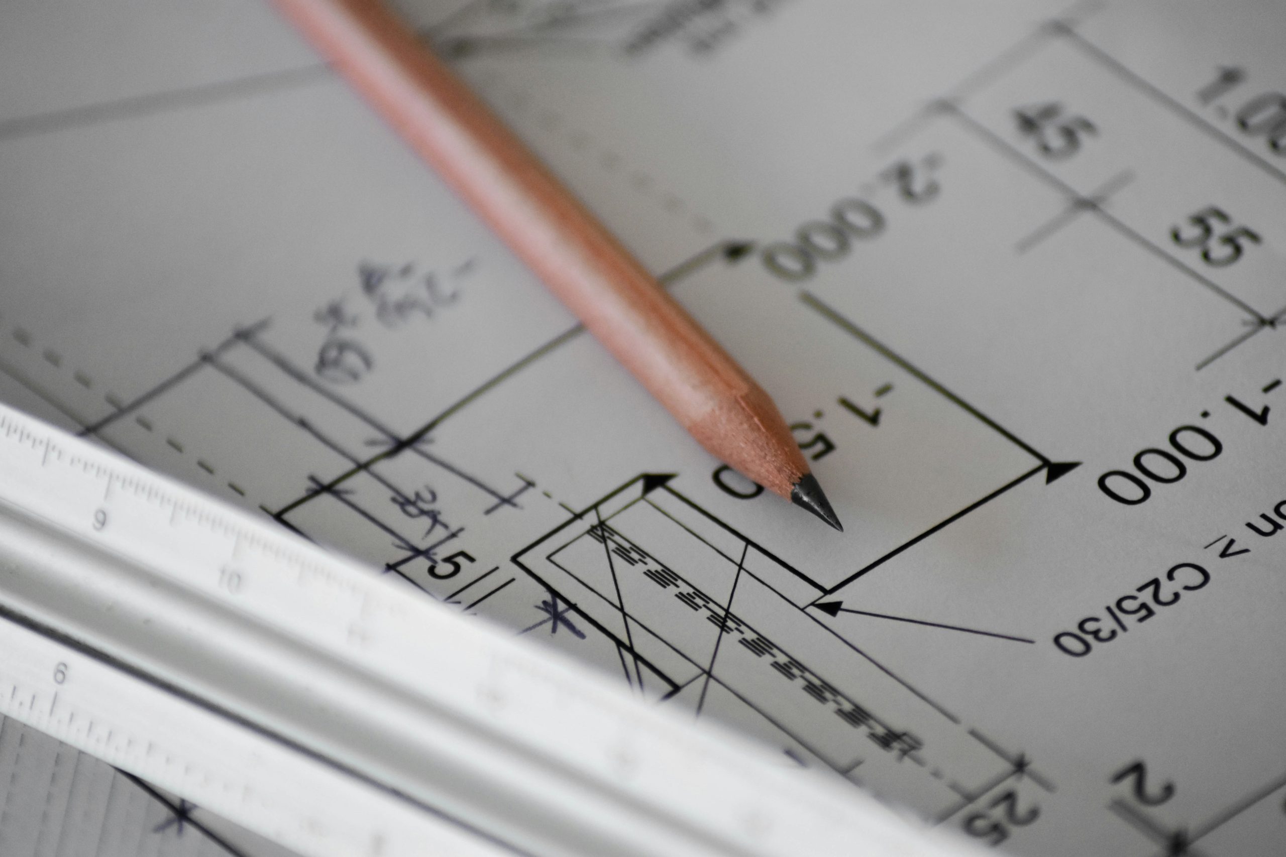 Plano de diseño de una vivienda con un lápiz encima